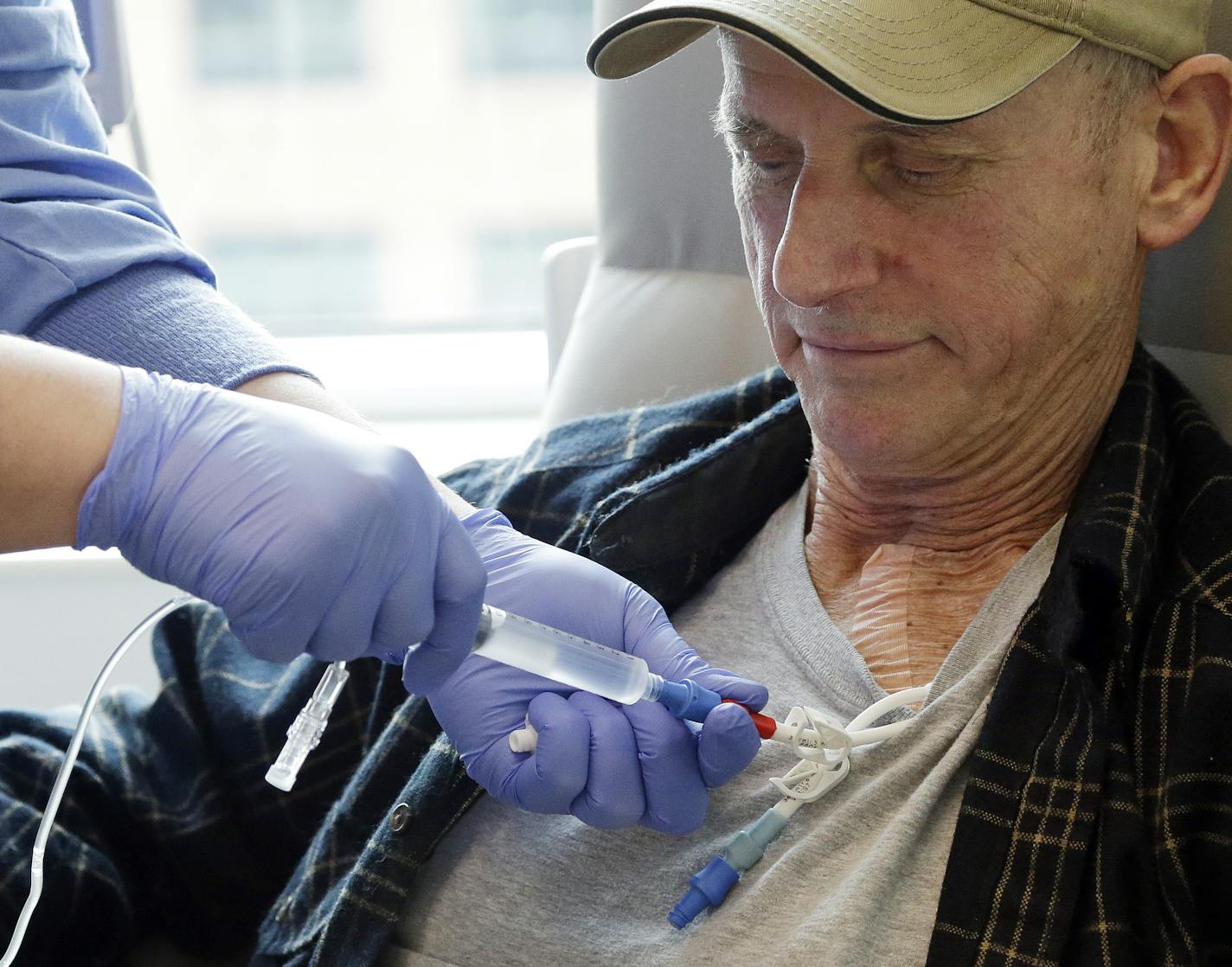 In this photo taken March 21, 2017, lymphoma patient Peter Bjazevich receives cellular immunotherapy as part of a study at the Fred Hutchinson Cancer Research Center in Seattle. Immune therapy is the hottest trend in cancer care and this is its next frontier, "living drugs" that grow inside the body into an army that seeks and destroys tumors. (AP Photo/Elaine Thompson) ORG XMIT: WX205