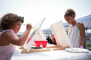 Alijah Sage, 5, left, and sister Aniyah Sage, 7, painted hearts on canvas during the Juneteenth Minnesota — A Family Celebration event outside Allia