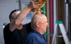 Steve Hoffman helped place "Strawberry" the hen on Andrew Zimmern's head for a photoshoot for a Midwest Living story at photographer Steve Henke's stu