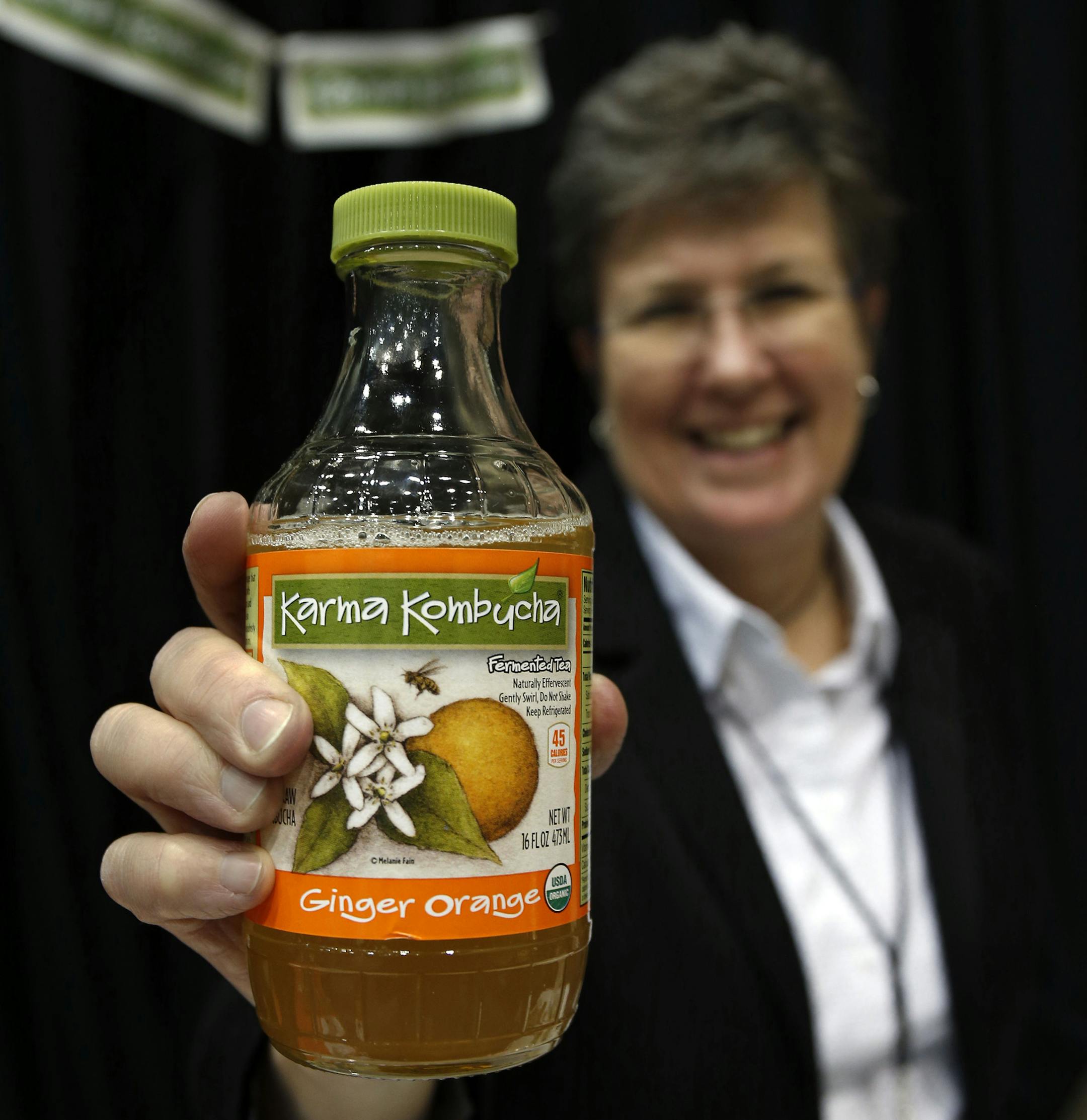 Susan Fink, founder and brewer of Karma Kombucha, holds a bottle of her Ginger Orange kombucha beverage at the Good Food Festival's financing and innovation conference on March 24, 2016, at the UIC Forum in Chicago. (Phil Velasquez/Chicago Tribune/TNS)