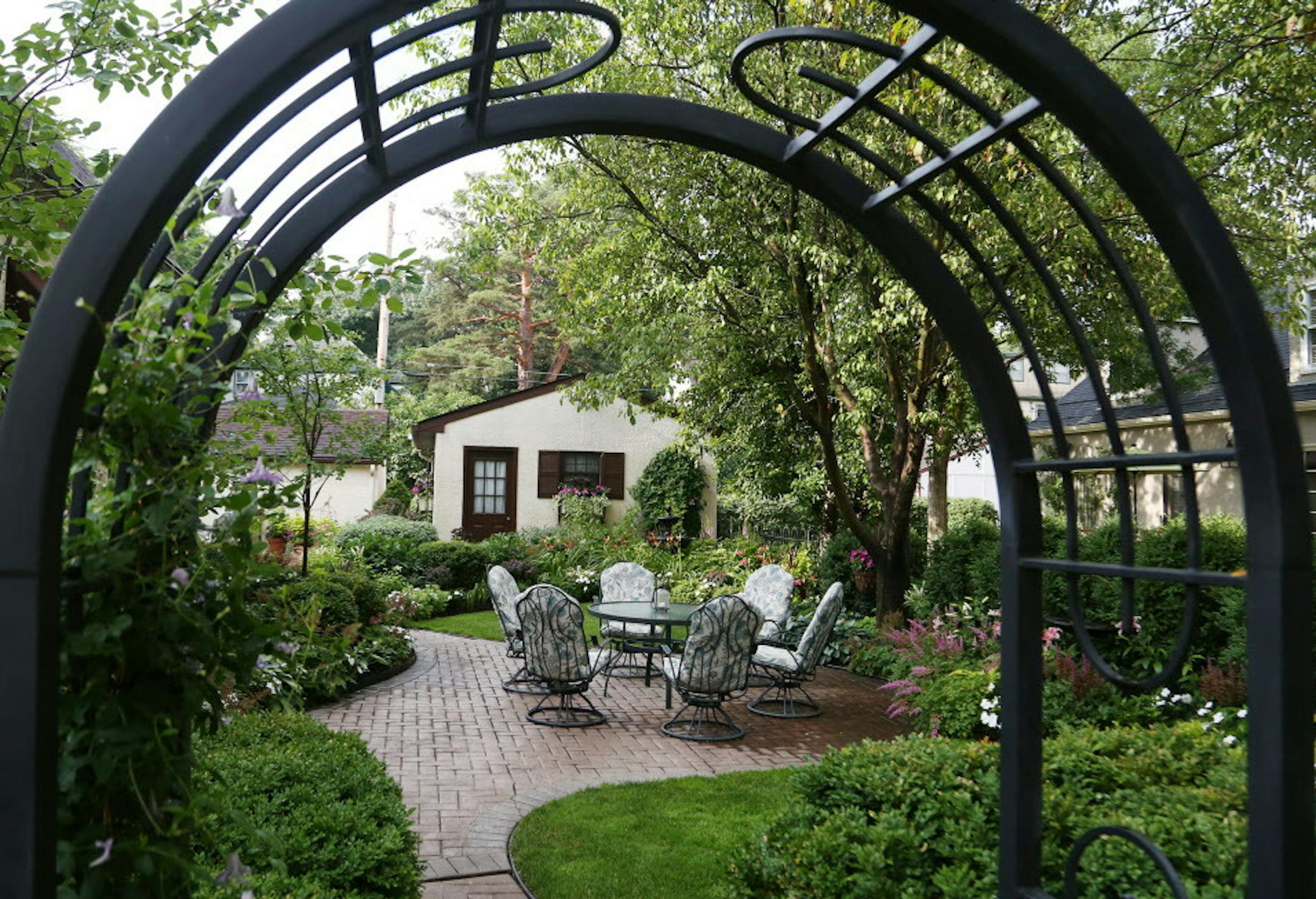 Kathy Freeman has created a mini-paradise in her small St. Paul yard, which includes this side garden, framed by a metal archway and seen Thursday, July 20, 2017, outside her home in St. Paul. MN] DAVID JOLES ï david.joles@startribune.com Kathy Freeman has created a mini-paradise in her small St. Paul yard. An inviting path beckons to the right of her front door. On the left, a well-trimmed serviceberry creates dappled shade for yet another inviting display of shade-loving plants. In the ba
