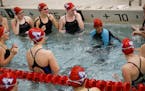 Suhan Mohamed, in swimsuit with blue arms, did a cheer in the water with her fellow teammates before a swim meet at Apollo High School in St. Cloud, M