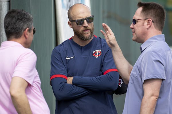 Twins manager Rocco Baldelli, center, talked with General Manager Thad Levine, left, and President of Baseball Operations Derek Falvey during spring t