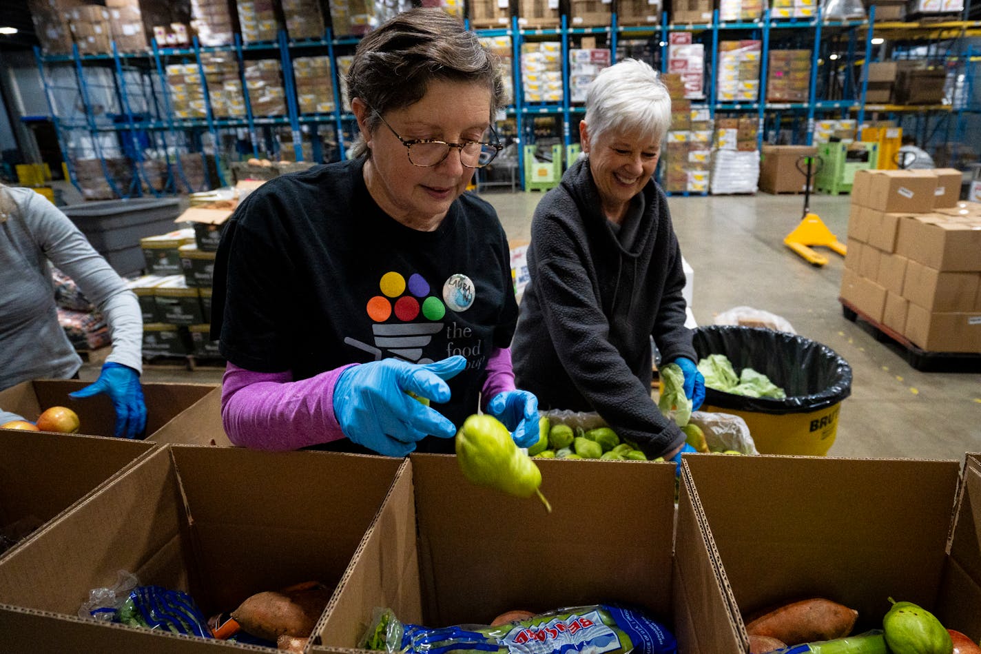 Laura Wennik, a volunteer with the Food Group, helps pack pears into produce boxes during the food bank's "Pack to the Max" event on the 15th annual Give to the Max Day at the Food Group in New Hope, Minn. on Thursday, Nov. 16, 2023. This day is the biggest one-day fundraiser for thousands of Minnesota schools and nonprofits and the Food Group is hoping to raise at least $100,000 by the end of the day. They are also distributing the boxes to food shelves and other affordable grocery programs in Minnesota to get healthy food in the hands of people in need. ] Angelina Katsanis • angelina.katsanis@startribune.com