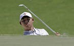 Si Woo Kim, of South Korea, chips onto the third green during the final round of The Players Championship golf tournament Sunday, May 14, 2017, in Pon