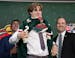 The Minnesota Wild's 19th pick, center, Liam Ohgren, puts on his jersey during the first round of the NHL hockey draft Thursday, July 7, 2022 in Montr