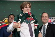 The Minnesota Wild's 19th pick, center, Liam Ohgren, puts on his jersey during the first round of the NHL hockey draft Thursday, July 7, 2022 in Montr