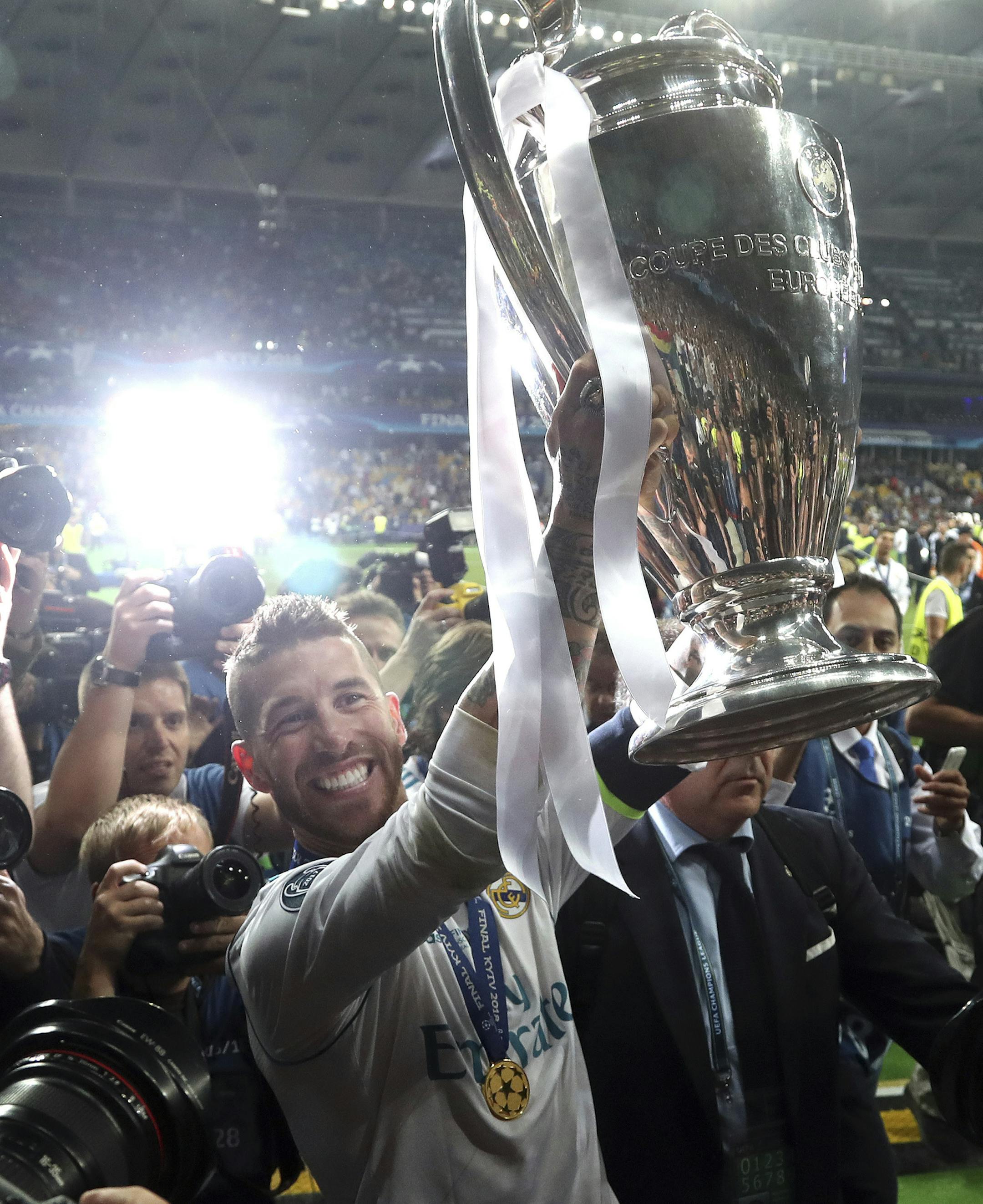 Real Madrid's Sergio Ramos celebrates with the trophy after winning the Champions League Final soccer match between Real Madrid and Liverpool at the Olimpiyskiy Stadium in Kiev, Ukraine, Saturday, May 26, 2018. (AP Photo/Sergei Grits)