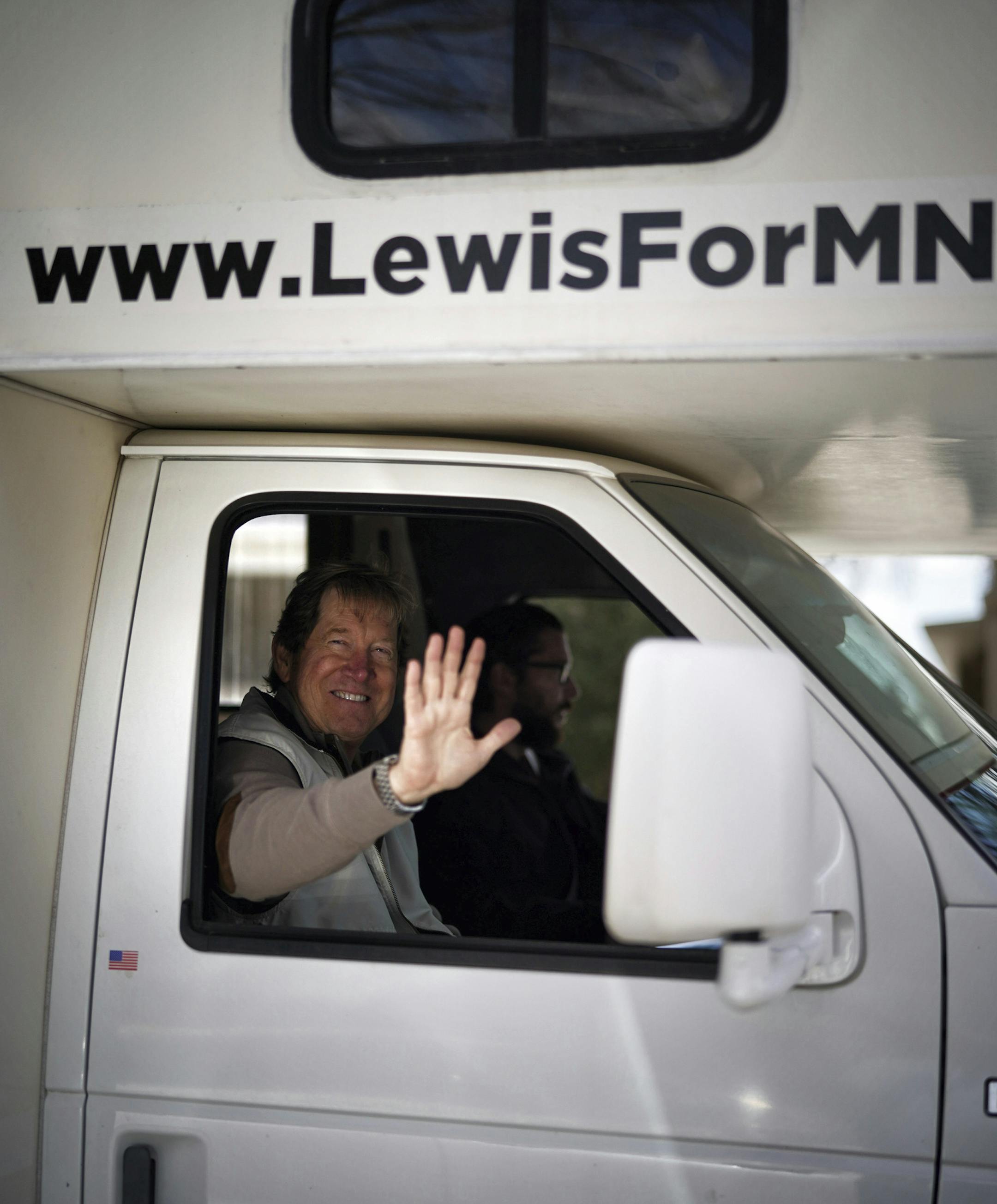 U.S. Senate candidate Jason Lewis waves from the parade of vehicles outside Minnesota Gov. Tim Walz' official residence, Friday, April 17, 2020 in St. Paul, Minn. President Donald Trump tweeted his support for a protest outside Gov. Tim Walz's official residence in St. Paul against Minnesota's continued stay-at-home order. (Glen Stubbe/Star Tribune via AP)