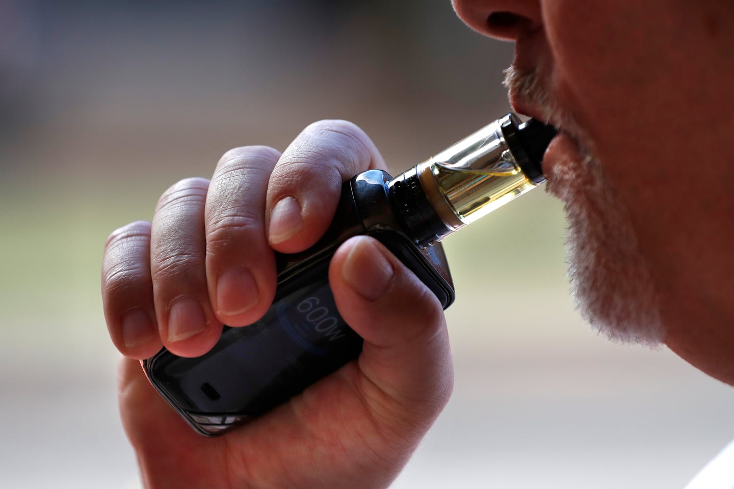 In this Aug. 28, 2019 photo a man smokes an e-cigarette in Portland, Maine. (AP Photo/Robert F. Bukaty) ORG XMIT: MER67b5446dd4796875b169998bcacdf