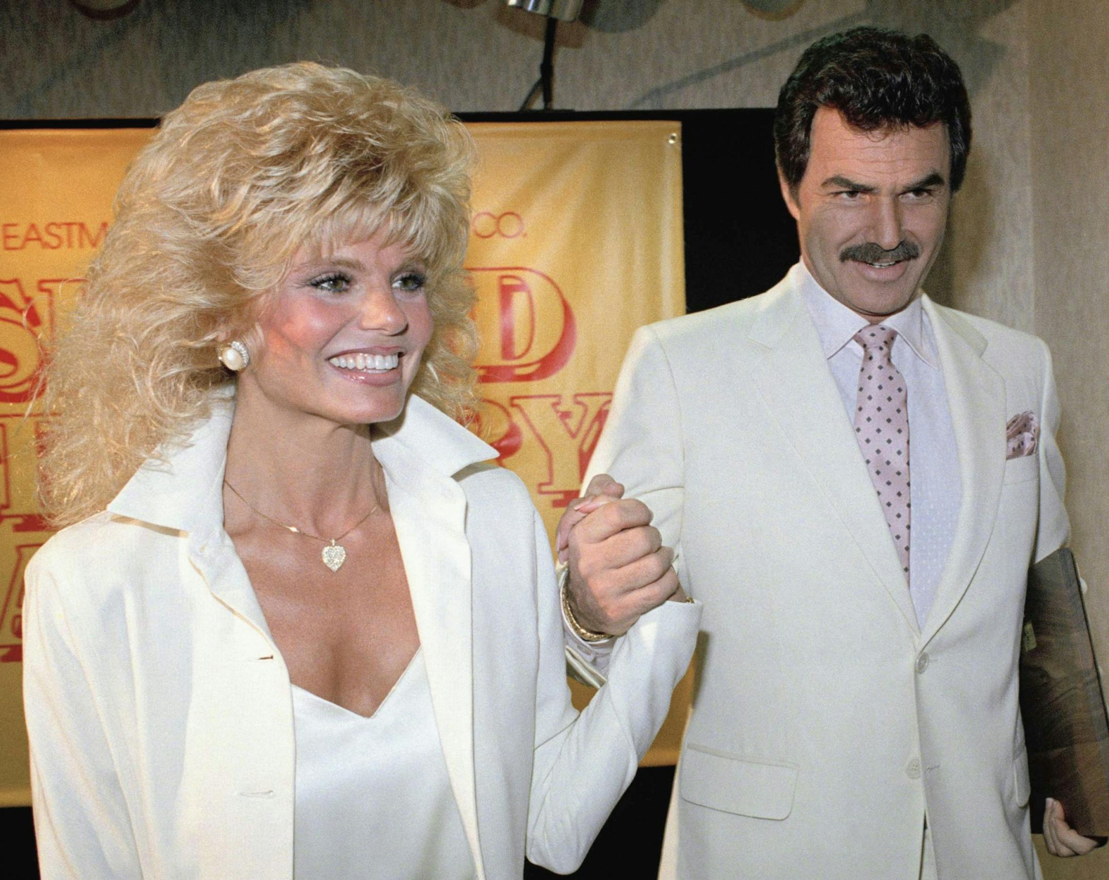 FILE - In this March 27, 1987 file photo, Burt Reynolds, right, holds hands with Loni Anderson at luncheon in Los Angeles. Reynolds, who starred in films including "Deliverance," "Boogie Nights," and the "Smokey and the Bandit" films, died at age 82, according to his agent.