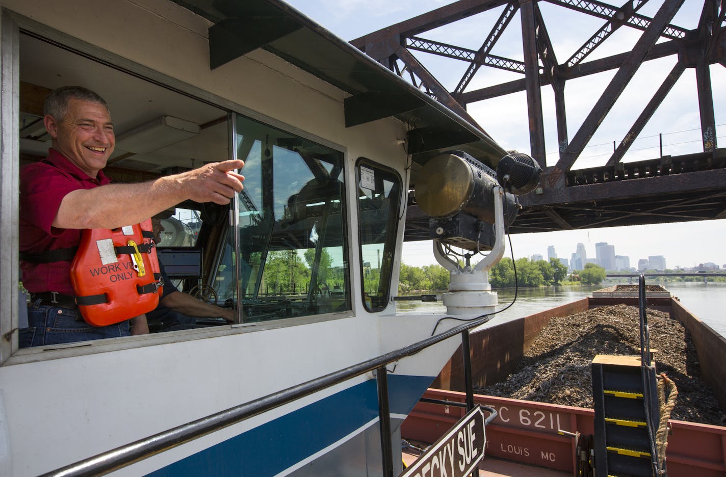 Lee Nelson, president of Upper River Services, waved Tuesday as he took the last tow of scrap metal through the Upper St. Anthony Falls lock.