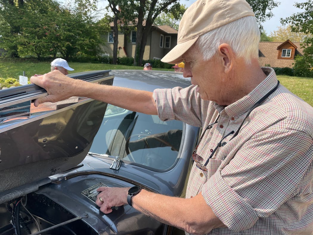 Dick Pearson of Bloomington read details from the sale badge of his 1940 Packard during a car show in Edina last weekend.