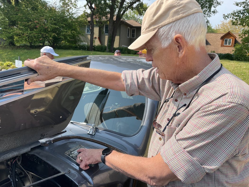 Dick Pearson of Bloomington read details from the sale badge of his 1940 Packard during a car show in Edina last weekend.