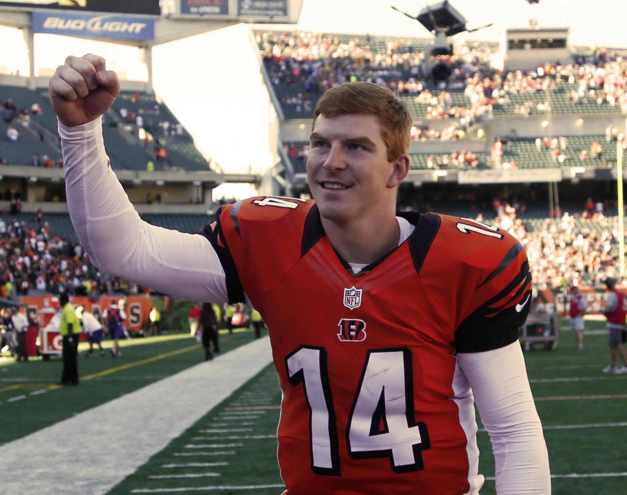 Cincinnati Bengals quarterback Andy Dalton runs off the field after they defeated the Green Bay Packers 34-30 in an NFL football game, Sunday, Sept. 22, 2013, in Cincinnati. (AP Photo/David Kohl) ORG XMIT: MIN2013101121244797