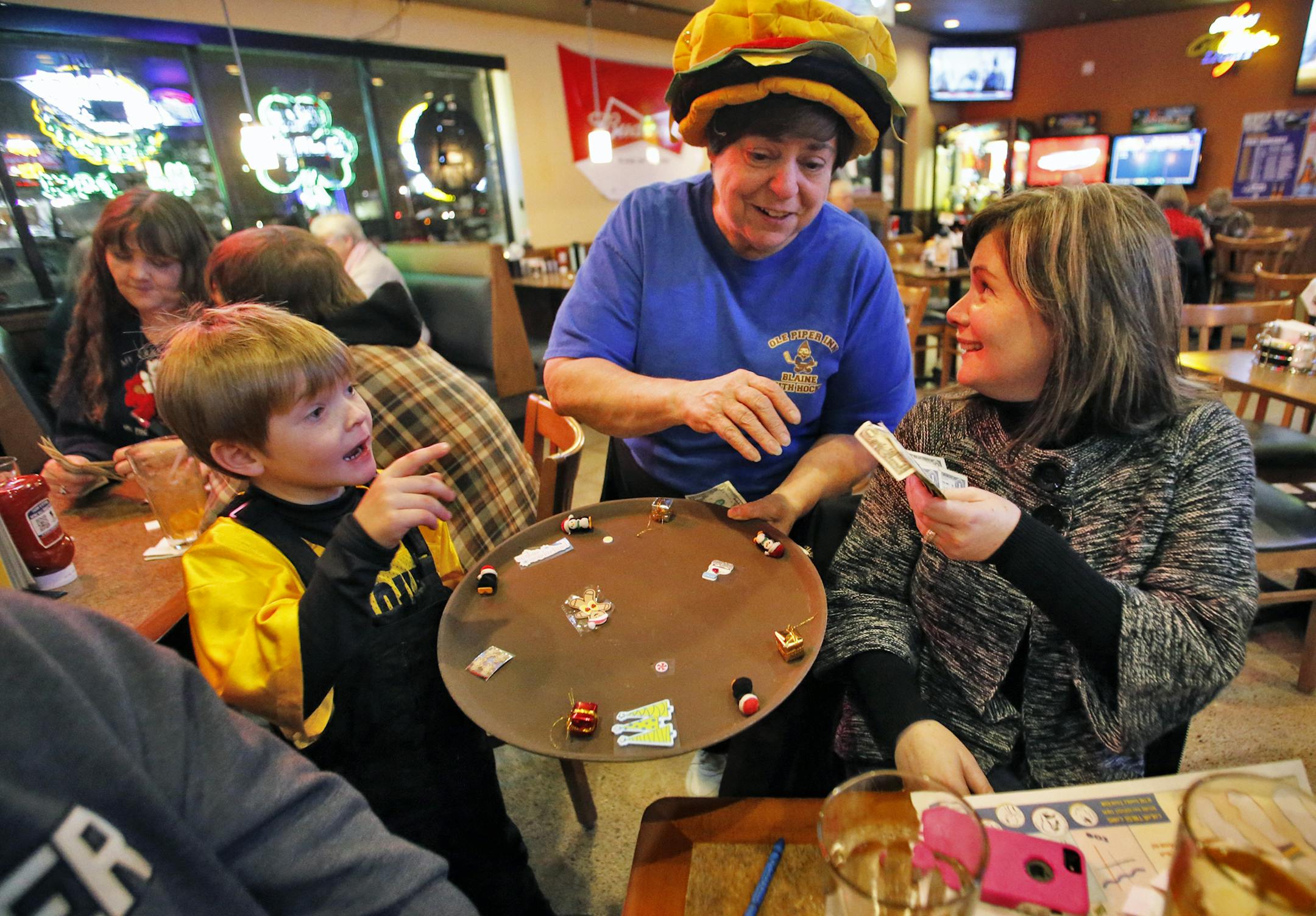 Anoka County leads the metro area in charitable gaming revenue accrued. A twice-weekly meat raffle held at Ole Piper Inn in Blaine is one of the vehicles used to obtain revenue for community projects such as youth sports. Blaine youth hockey volunteer Vicki Paul, center, sold a meat raffle ticket to Kelly Babineau, right, as her son Luke Babineau, 9, looked on. The Babineau family were on their way to youth hockey practice in Blaine. (MARLIN LEVISON/STARTRIBUNE(mlevison@startribune.com)