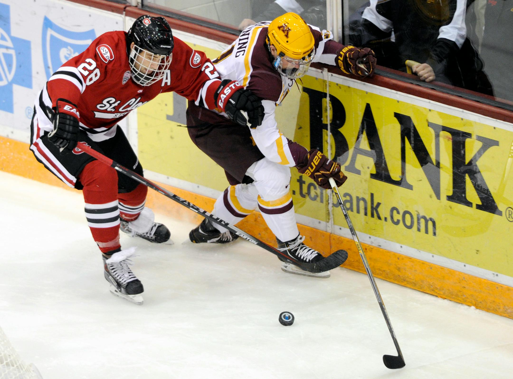 St. Cloud State defenseman Andrew Prochno (28) keeps Minnesota forward Sam Warning away from the puck during the first period of an NCAA college hockey game on Saturday, Nov. 1, 2014, in Minneapolis. (AP Photo/Hannah Foslien)