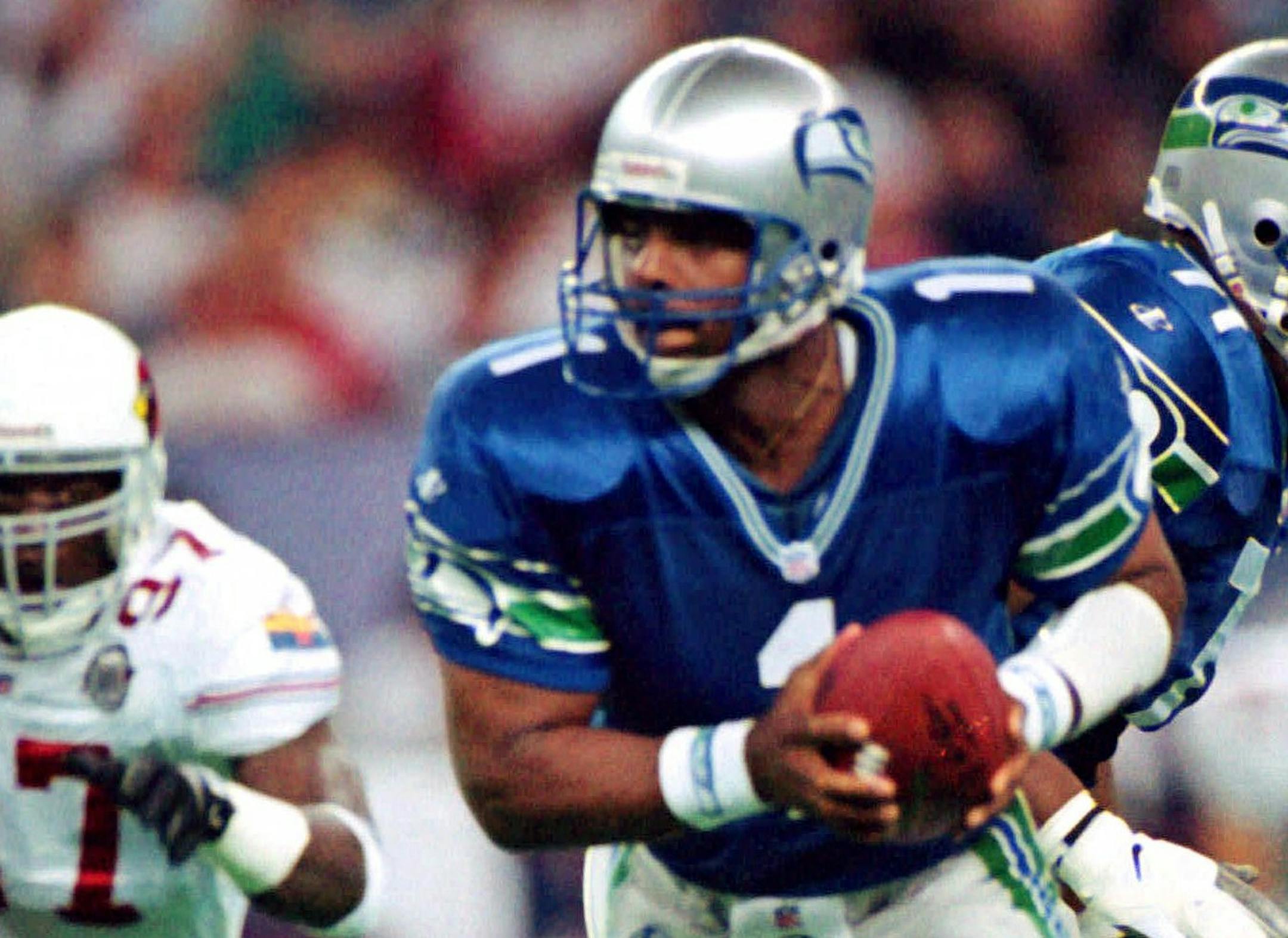 FILE -- Seattle Seahawks Warren Moon (1) falls back and looks for a receiver as Arizona Cardinals' Simeon Rice (97) is on the move in this Sept. 13, 1998 file photo in Seattle. After waltzing past three NFC East teams by a margin of 95-28, they go into Pittsburgh on Sunday, Sept. 27, followed by a trip to Kansas City and a home game against Denver.(AP Photo/Barry Sweet) ORG XMIT: MIN2013080415232430