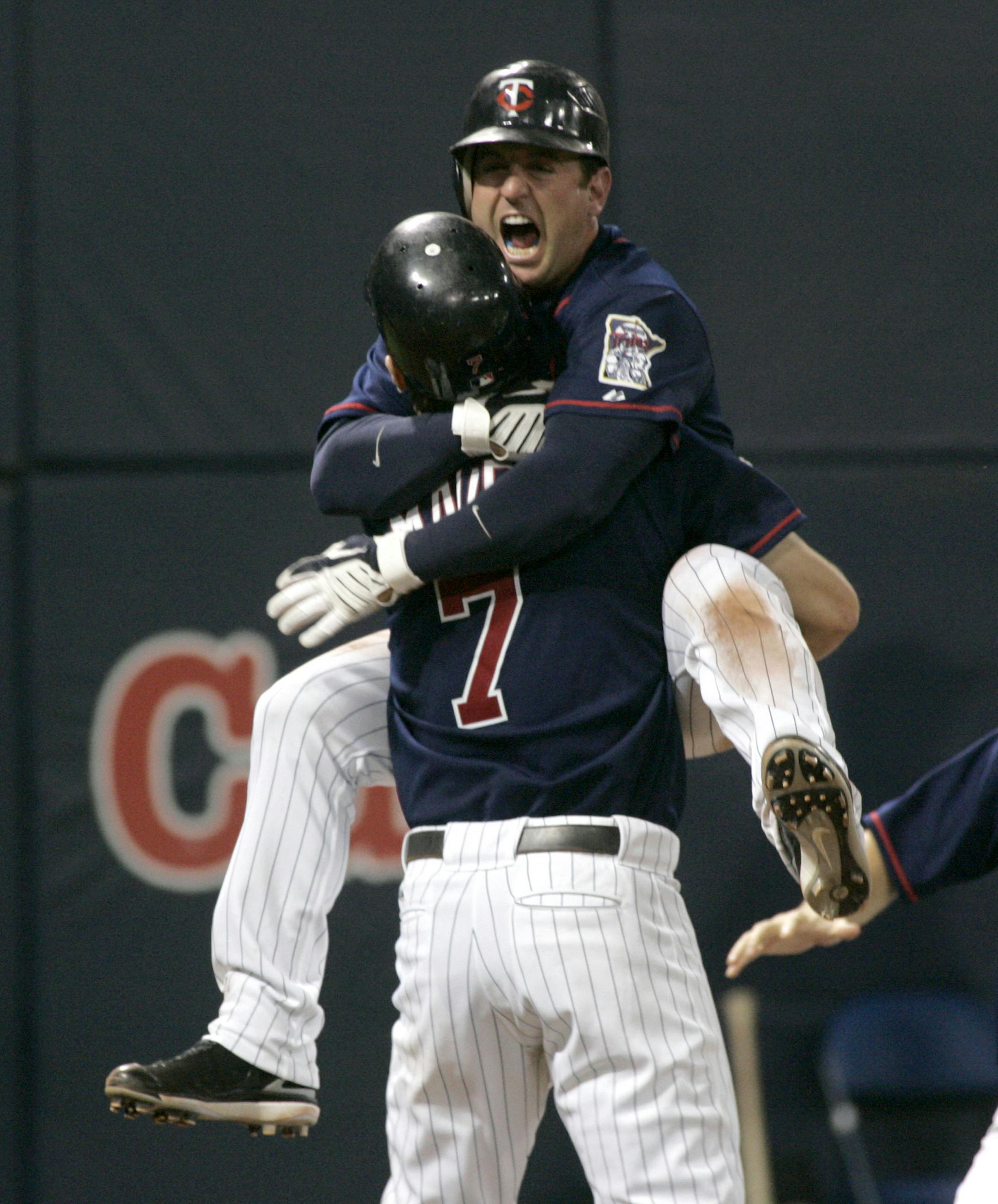 Minnesota Twins shortstop Nick Punto celebrates with teammate Joe Mauer (7) after he scored the winning run during the tenth inning of a baseball game against the Chicago White Sox on Thursday, Sept. 25, 2008, in Minneapolis. The Twins won 7-6.