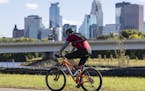 A cyclist rode past on a path in the future home of a park next to the Graco factory with a view of downtown. The Minneapolis Park Board says it has r
