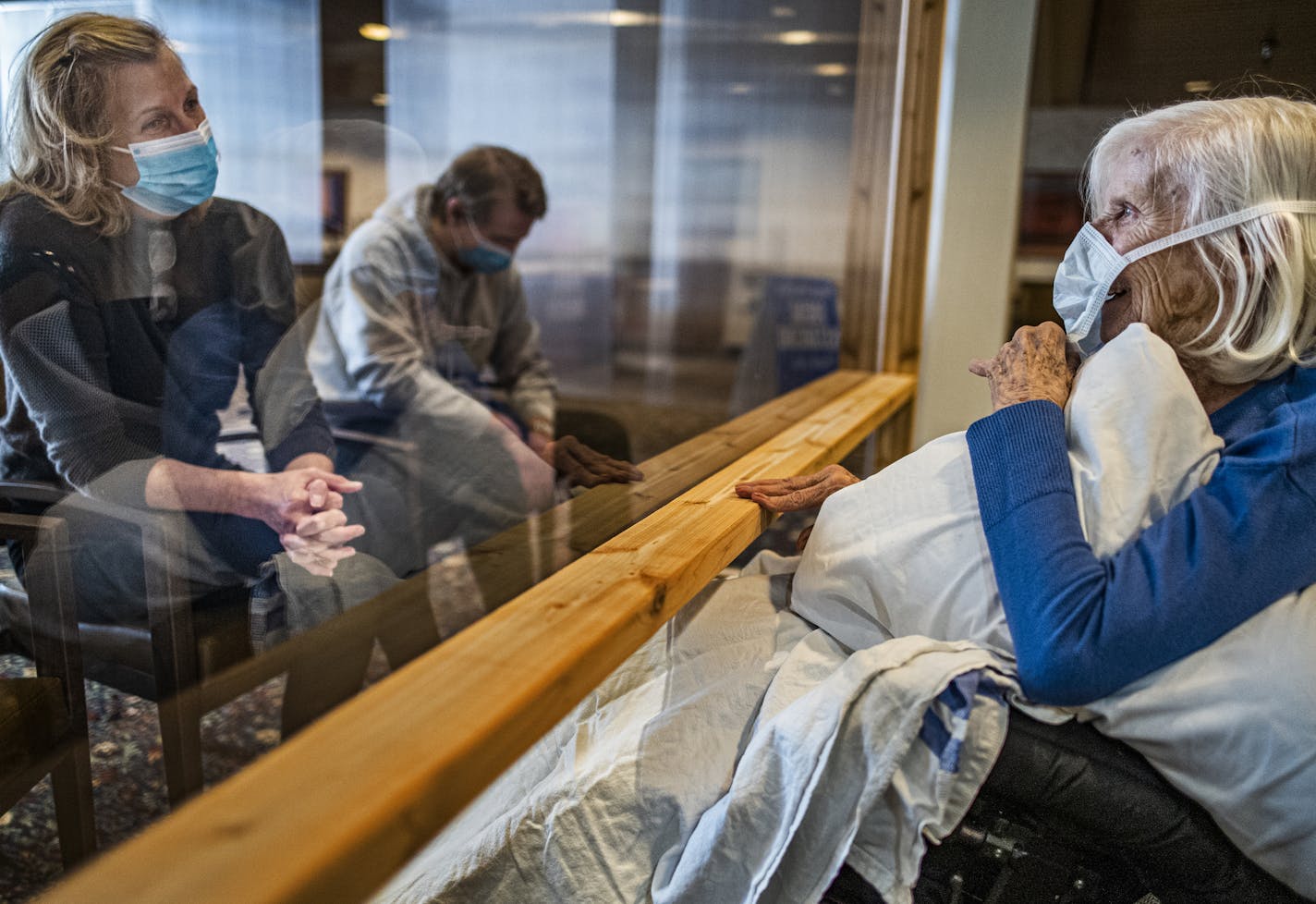 Carla Gillespie with her son Dylan visited her mother, Evelyn Solberg at the Jones-Harrison Residence on Monday, Oct. 12. It was the first time families have been allowed to visit residents inside nursing homes while masked up and behind a plastic shield since March.