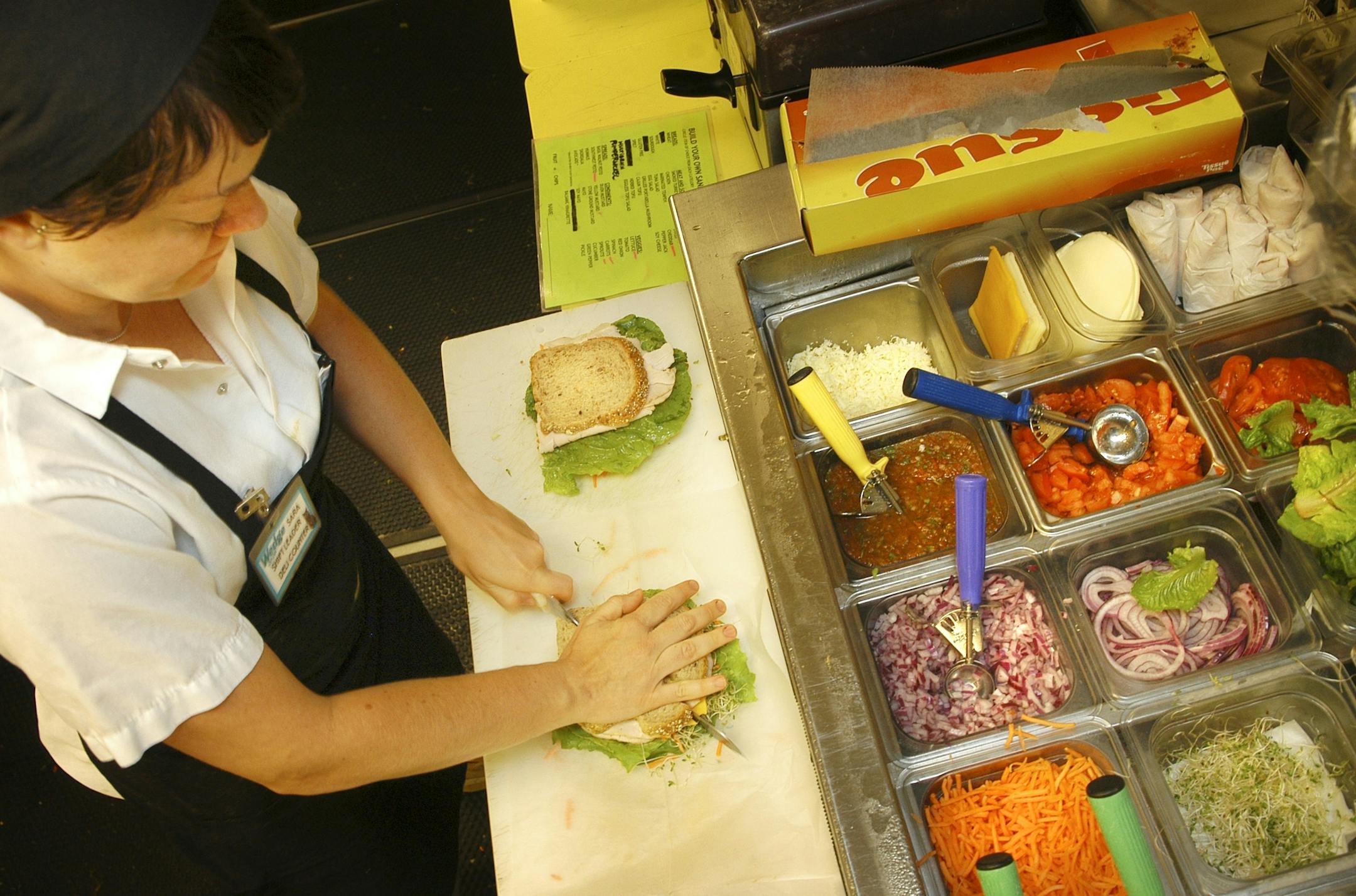 Glen Stubbe/Star Tribune Wednesday, July 20, 2005 -- Minneapolis, Minn. -- Sara Troy prepares sandwiches at the Wedge Co-op's deli. ORG XMIT: MIN2014010118161743