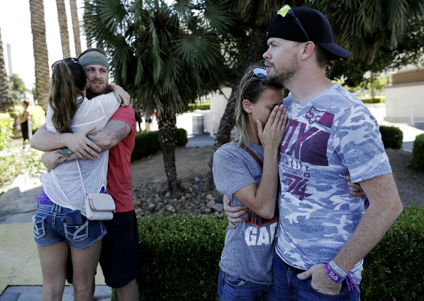 Sean Bean, of Livermore, Calif., hugs his girlfriend Katie Kavetski, of San Leandro, Calif., left, as Travis Reed, of Mexico, Ind., right, comforts his girlfriend Anna Travnicek, second from right, on Las Vegas Strip, Monday, Oct. 2, 2017, in Las Vegas. All attended a concert where a mass shooting occurred on Sunday. (AP Photo/Marcio Jose Sanchez)