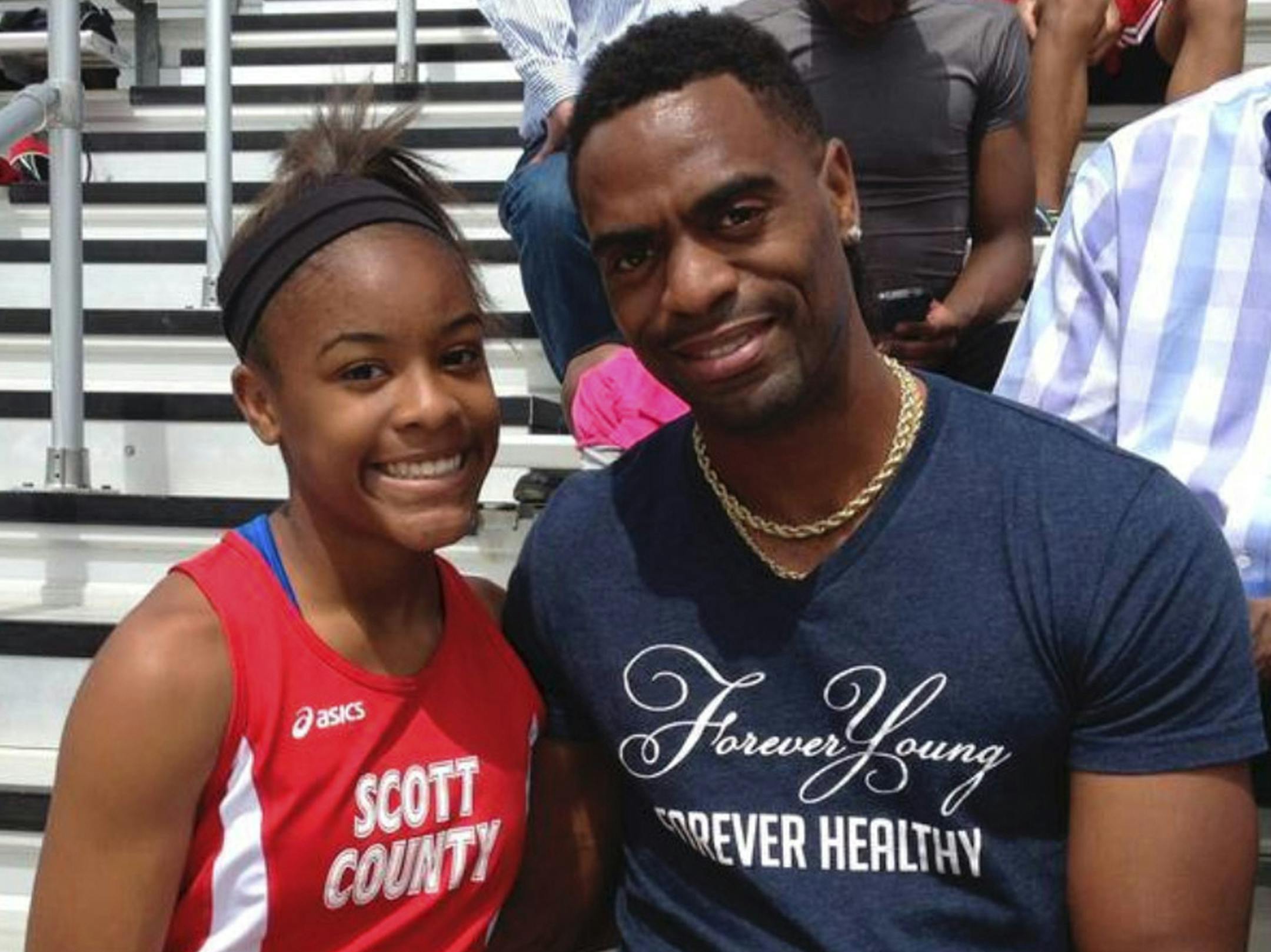 FILE - In this May 3, 2014, file photo, Trinity Gay, a seventh-grader racing for her Scott County High School team, poses for a photo with her father, Tyson Gay, after she won the 100 meters and was part of the winning 4-by-100 and 4-by-200 relays at the meet in Georgetown, Ky. The heartache still weighs heavily on Tyson Gay. But he keeps sprinting in her memory. The 15-year-old daughter of the Olympic sprinter was shot and killed in October outside a restaurant in Lexington, Kentucky. "You neve