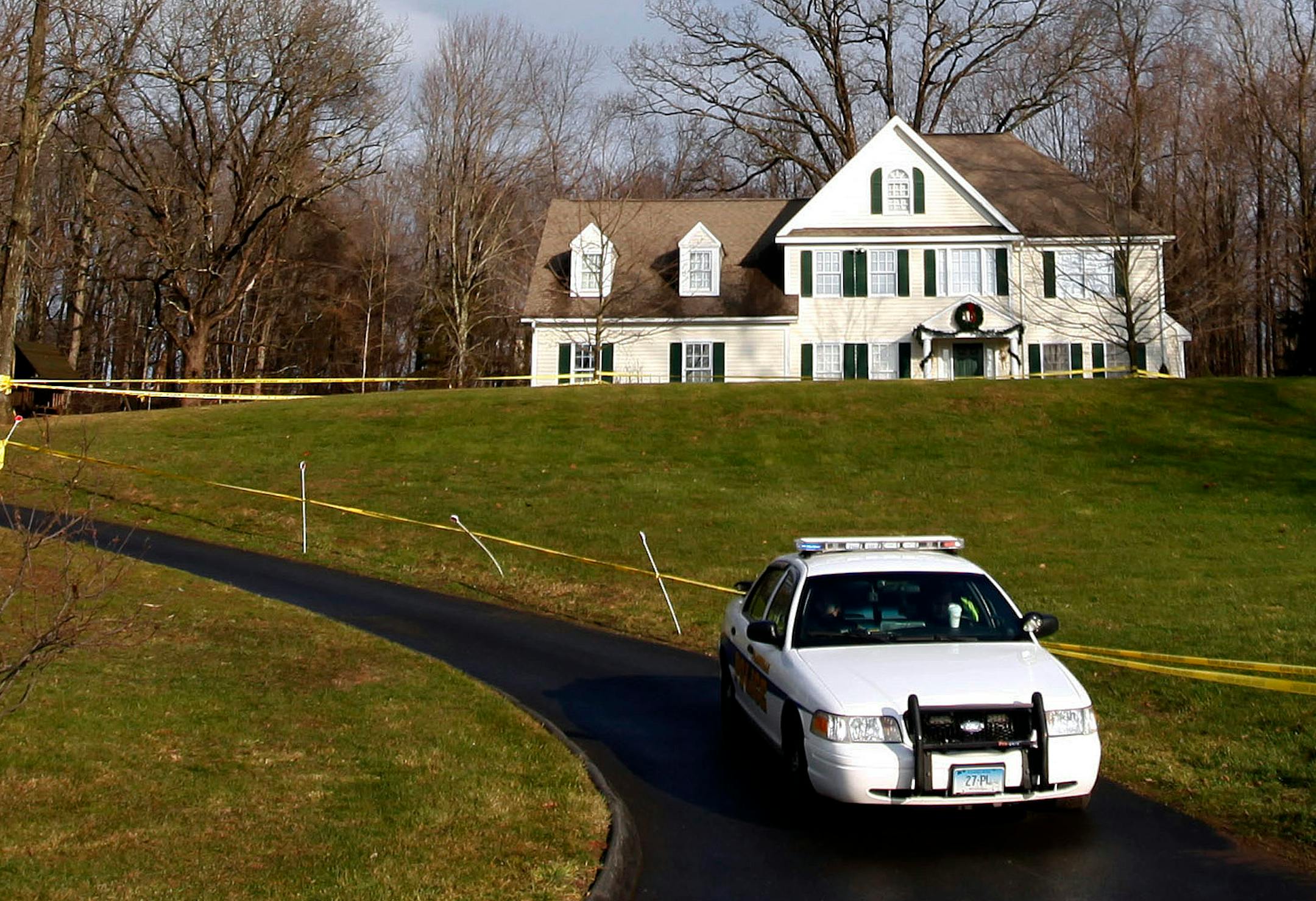 In this Dec. 18, 2012, file photo, a police cruiser sits in the driveway and crime scene tape surrounds the home of Nancy Lanza in Newtown, Conn. Search warrants released Thursday, March 28, 2013, revealed that an arsenal of weapons including guns, more than a thousand rounds of ammunition, a bayonet and several swords was seized in the Lanza home.