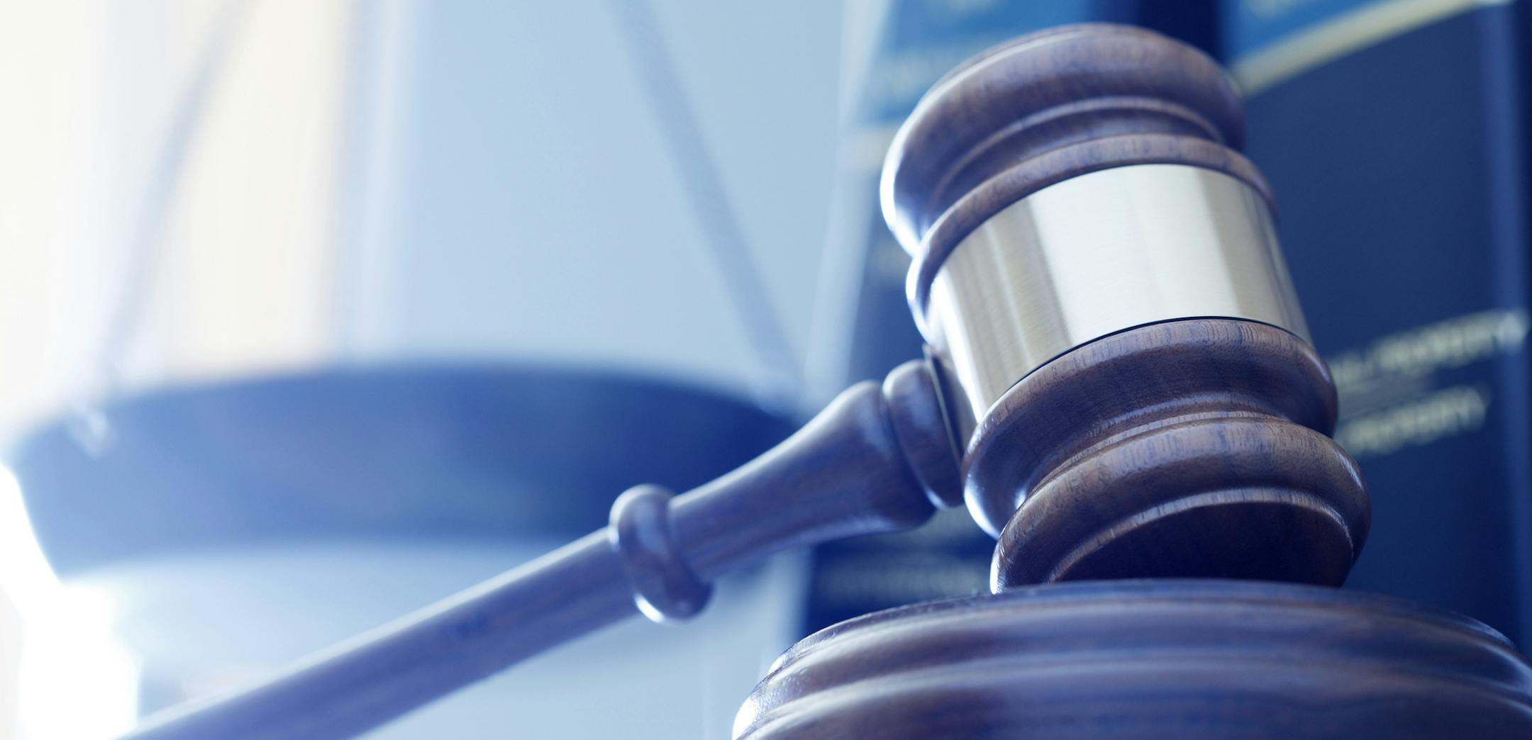 iStock
A gavel rests on its sounding block with a several law books and a justice scale out of focus in the background.