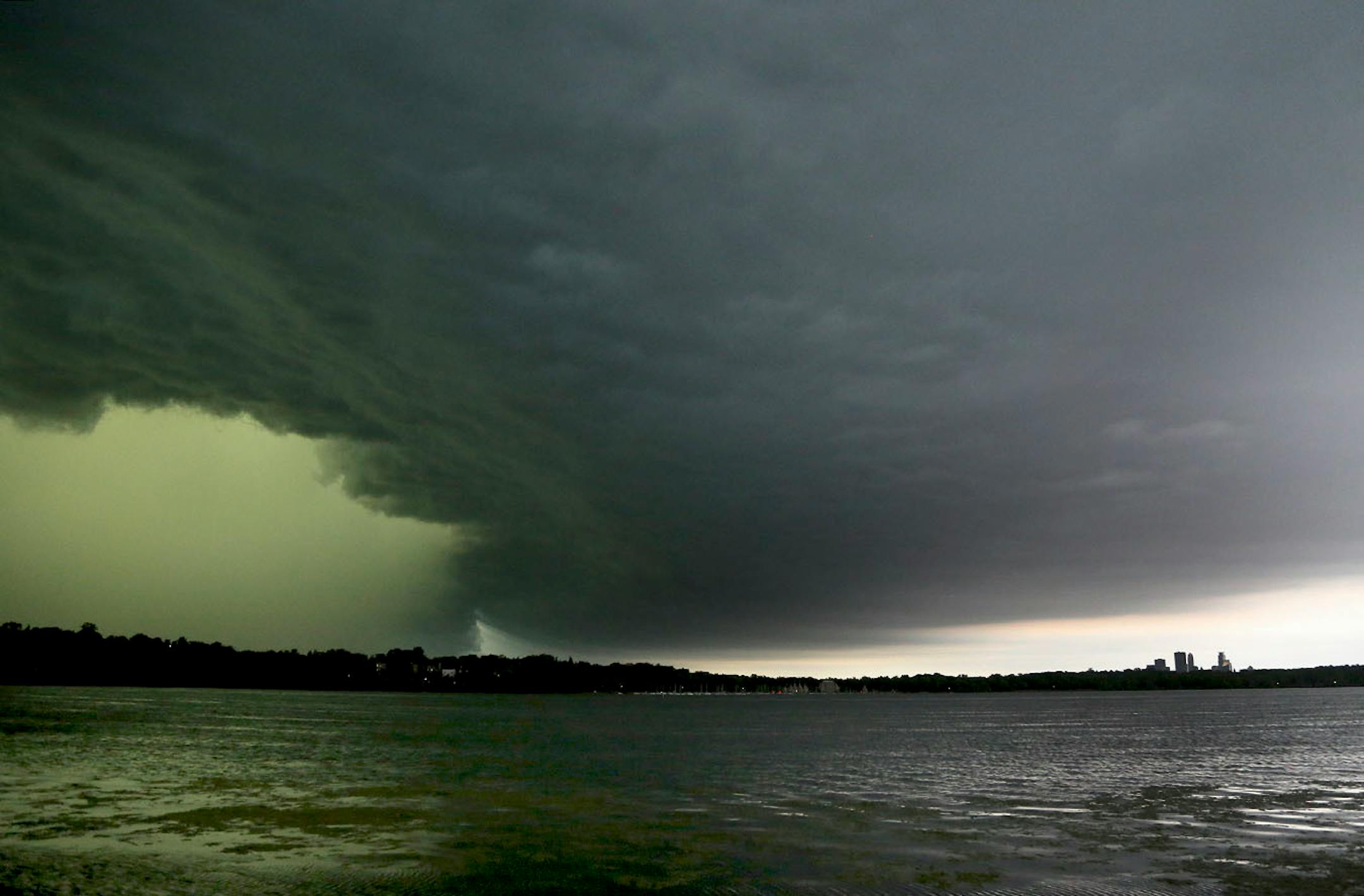 A severe thunderstorm rolls east towards downtown Minneapolis, lower right, seen from the south side of Lake Harriet Sunday, June 11, 2017, in Minneapolis, MN.