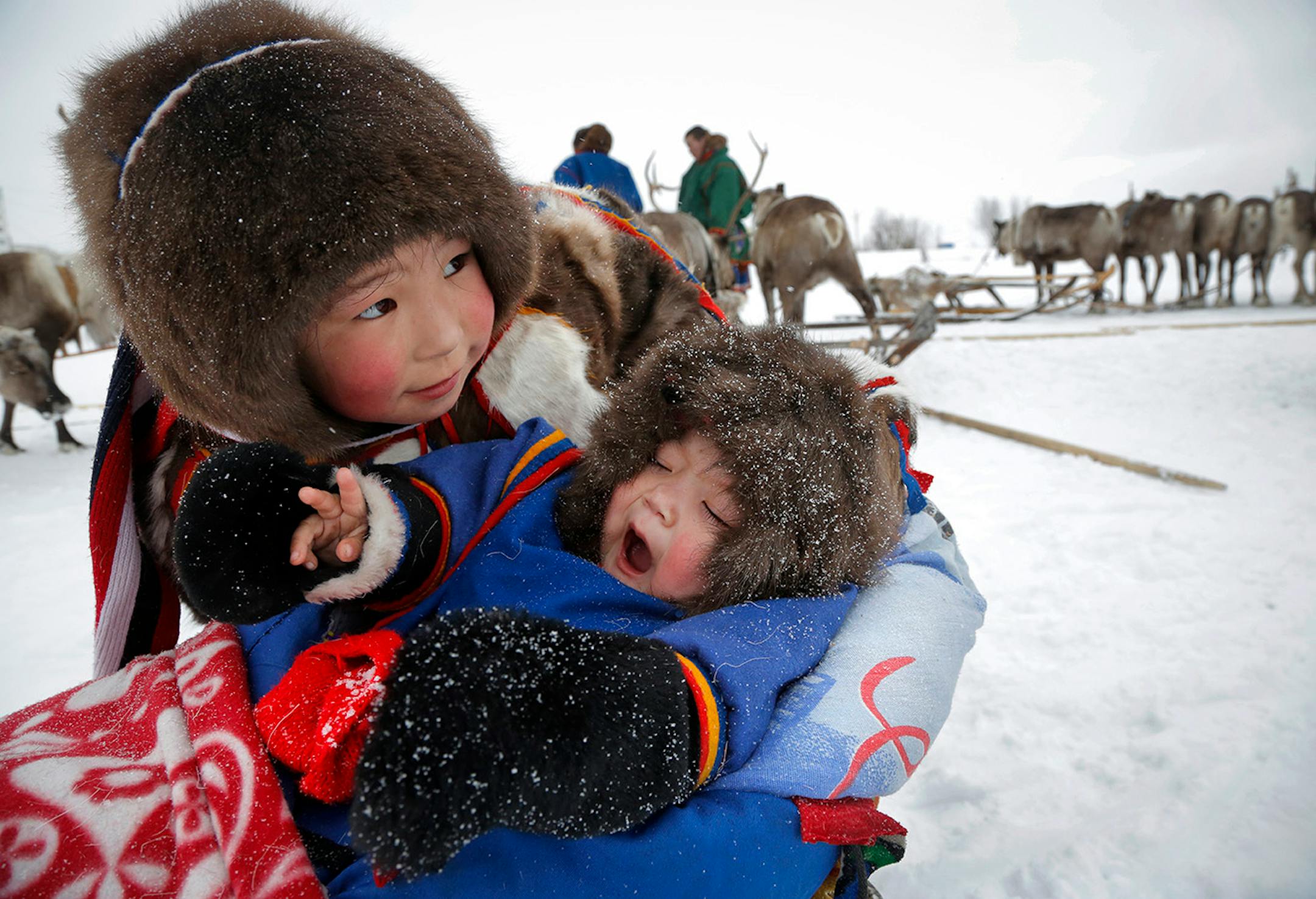 In this photo taken on Sunday, March 15, 2015, Nenets children attend the Reindeer Herder's Day holiday in the city of Nadym, in Yamal-Nenets Region, 2500 kilometers (about 1553 miles) northeast of Moscow, Russia. For the indigenous nomadic Nenets people, the Reindeer Herder�s Day offers a chance to show their prowess in wrestling, high jumps and other traditional local sports, but, above all, reindeer races.