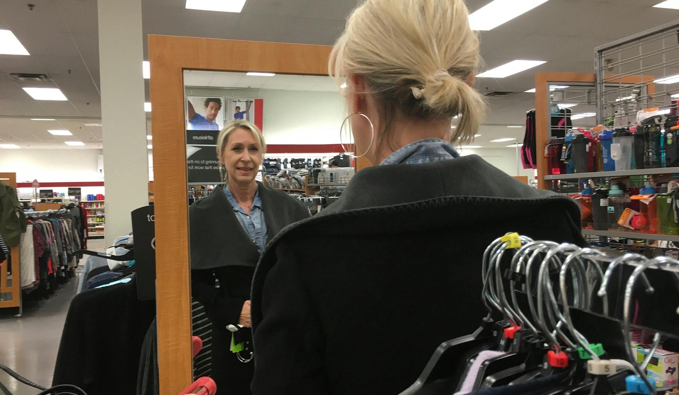 Tabitha Dardes tries on a marked down designer coat at the TJMAXX in Langhorne, Pa. "I love the selection here," she said. (Suzette Parmley/Philadelphia Inquirer/TNS) ORG XMIT: 1191805