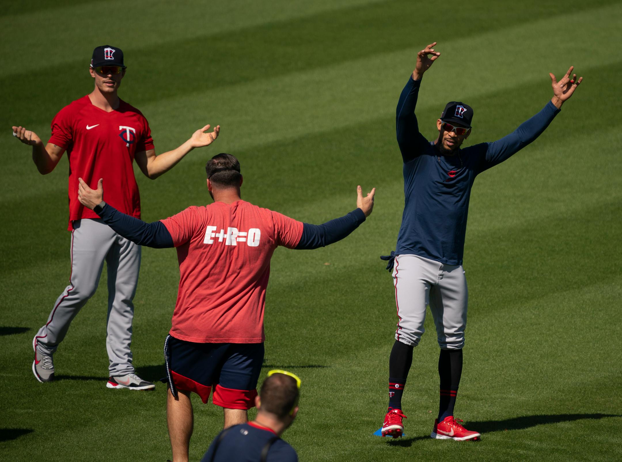 Minnesota Twins center fielder Byron Buxton celebrated a nice throw - with a football - as players warmed up for the first full squad workout Tuesday morning. At left was Twins right fielder Max Kepler.