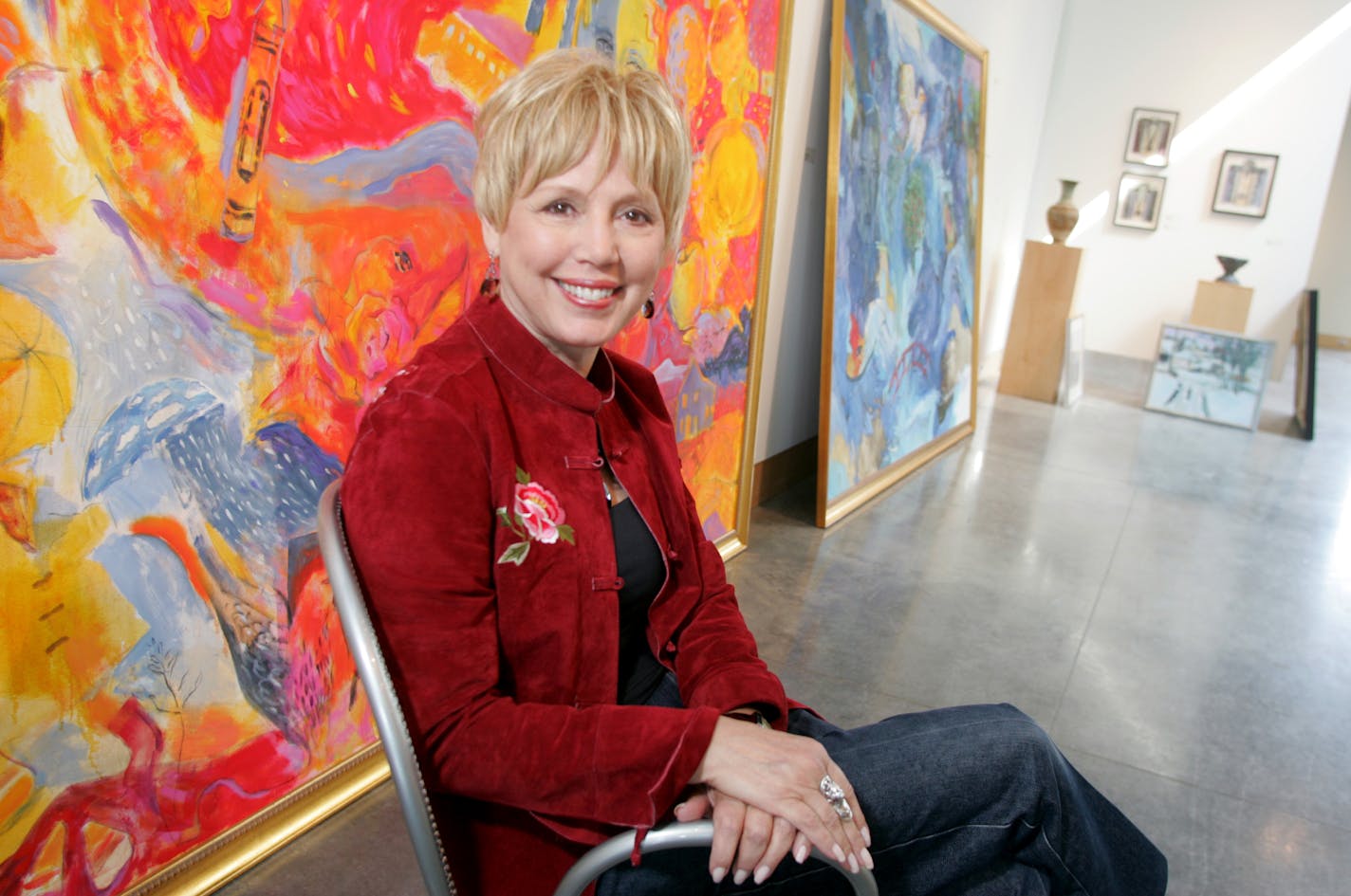 Jennifer Simonson/Star Tribune Wayzata, MN-Mon., Sept. 27, 2004 Minneapolis artist Miranda Moss with her colorful painting "Fall" (foreground, behind Moss).