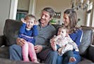 Minnesota Wild's Ryan Carter poses for a family photo with wife Erin and daughters Maggie, 3, left, and Natalie, 15 months, at their home in Gem Lake 