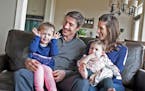 Minnesota Wild's Ryan Carter poses for a family photo with wife Erin and daughters Maggie, 3, left, and Natalie, 15 months, at their home in Gem Lake 