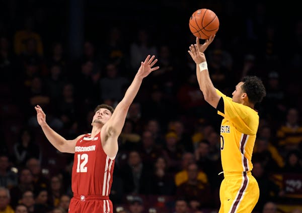 Wisconsin's Trevor Anderson guards against a three-point shot by Minnesota's Payton Willis during the second half on Feb. 5