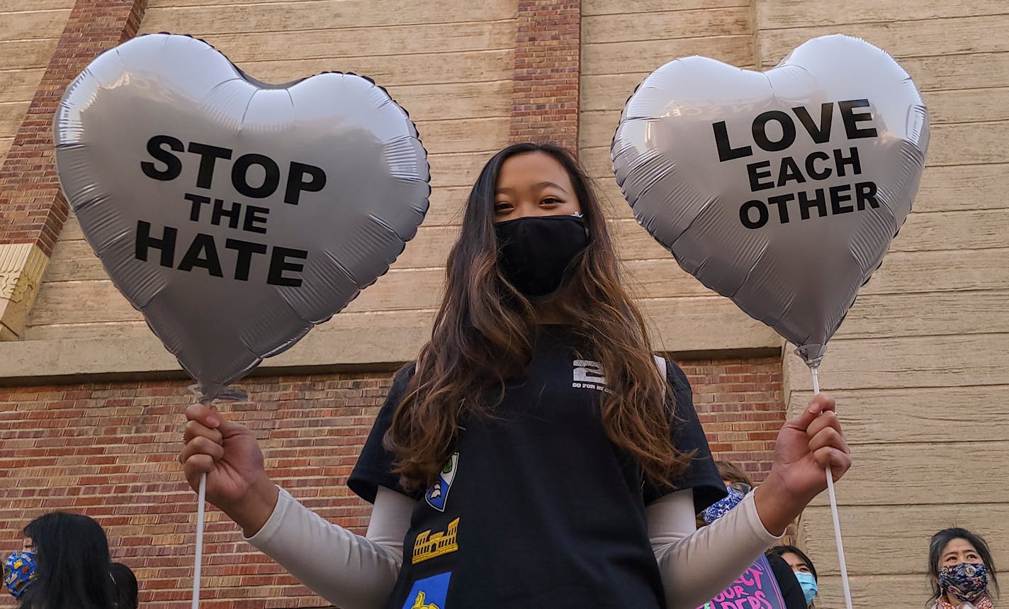 FILE - In this March 13, 2021, file photo, Chinese-Japanese American student Kara Chu, 18, holds a pair of heart balloons decorated by herself for the rally "Love Our Communities: Build Collective Power" to raise awareness of anti-Asian violence outside the Japanese American National Museum in Little Tokyo in Los Angeles.