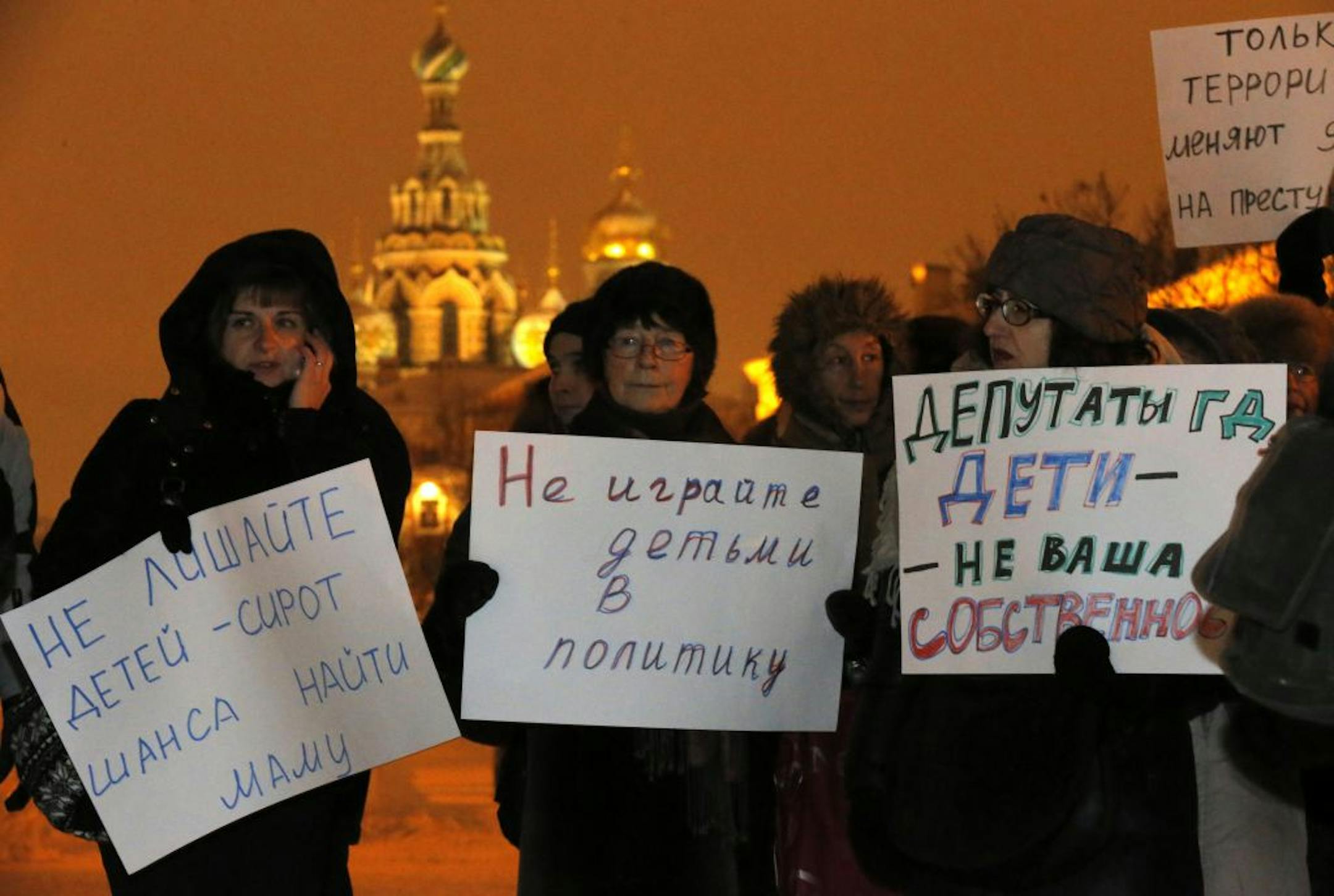 Opposition activists in St. Petersburg, Russia, hold posters reading "Do not involve children in politics" and "Lawmakers, children are not your ownership" during a protest the banning U.S. adoptions of Russian children.