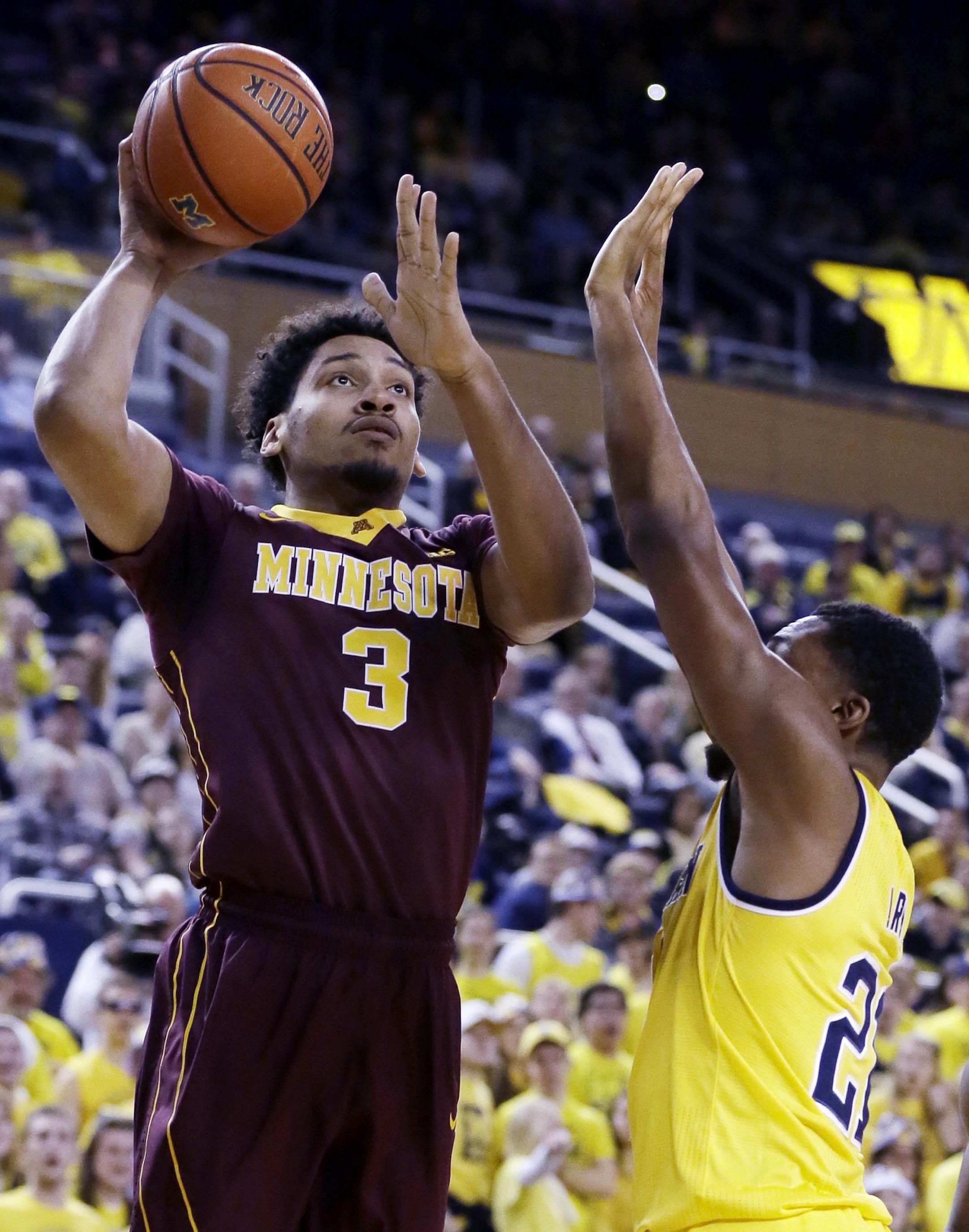 Minnesota forward Jordan Murphy (3) shoots over the defense of Michigan guard Zak Irvin (21) during the first half of an NCAA college basketball game, Wednesday, Jan. 20, 2016 in Ann Arbor, Mich. (AP Photo/Carlos Osorio)