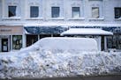 A van was completely snowed in by plows on Superior Street in downtown Duluth Sunday afternoon, which was quiet on a traditionally busy holiday shoppi