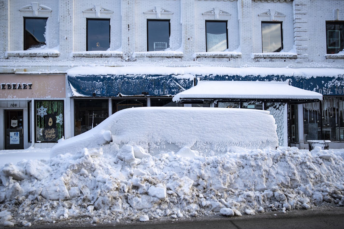 A van was completely snowed in by plows on Superior Street in downtown Duluth Sunday afternoon, which was quiet on a traditionally busy holiday shopping weekend. ORG XMIT: MIN1912011731432698