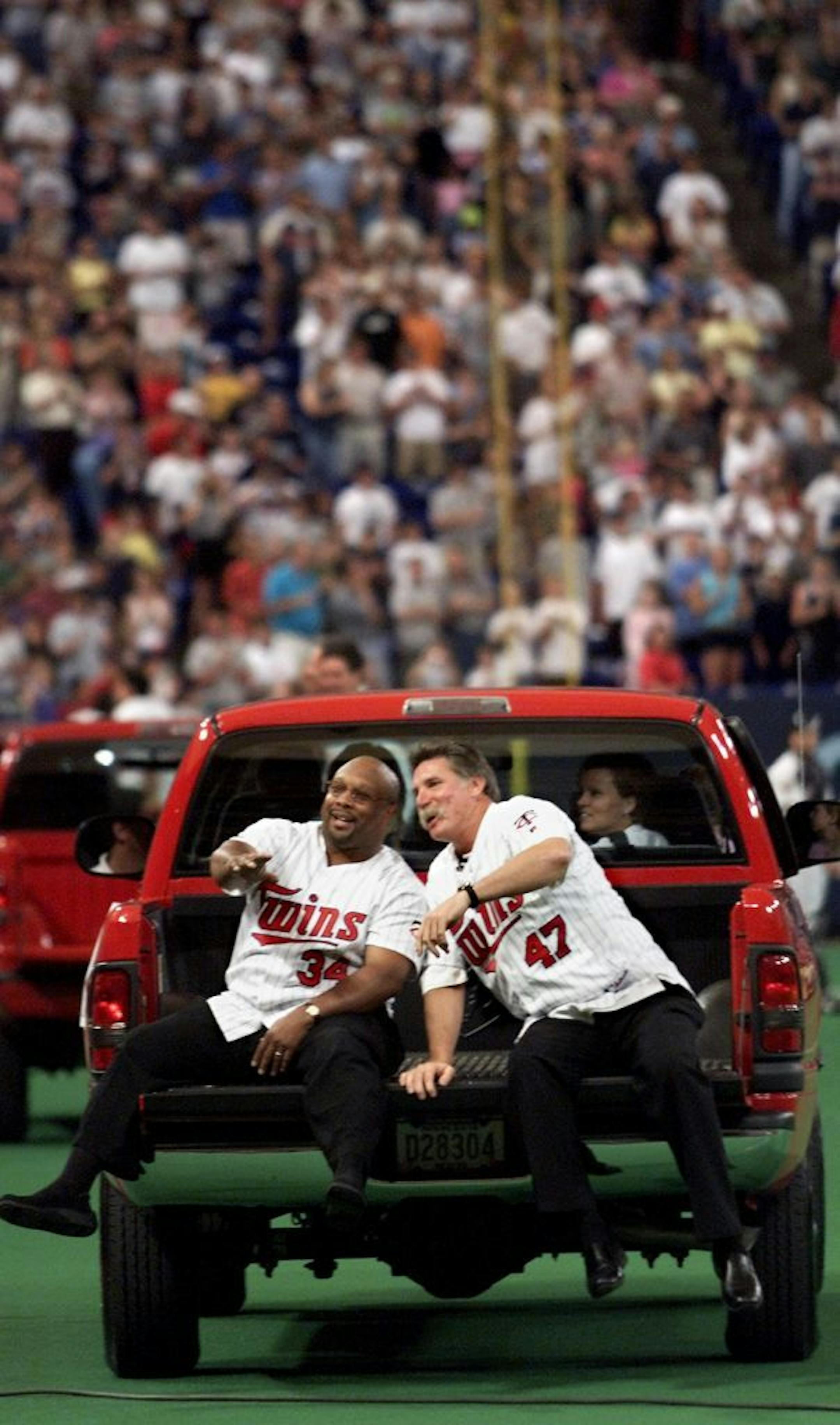 Kirby Puckett and Jack Morris, stars from the 1991 Twins championship team acknowledge the crowd as they ride the perimeter of the Metrodome on a pickup truck during pregame festivities honoring the team.