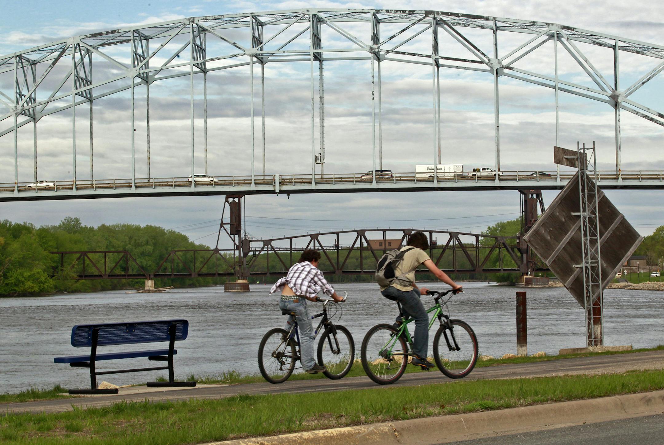 The Hastings bike path follows the shoreline of the Mississippi River with the historic Highway 61 bridge in the background.