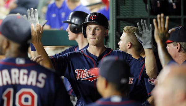 Minnesota Twins' Max Kepler is congratulated in the dugout after Kepler hit a two-run home run off of Texas Rangers relief pitcher Shawn Tolleson in t