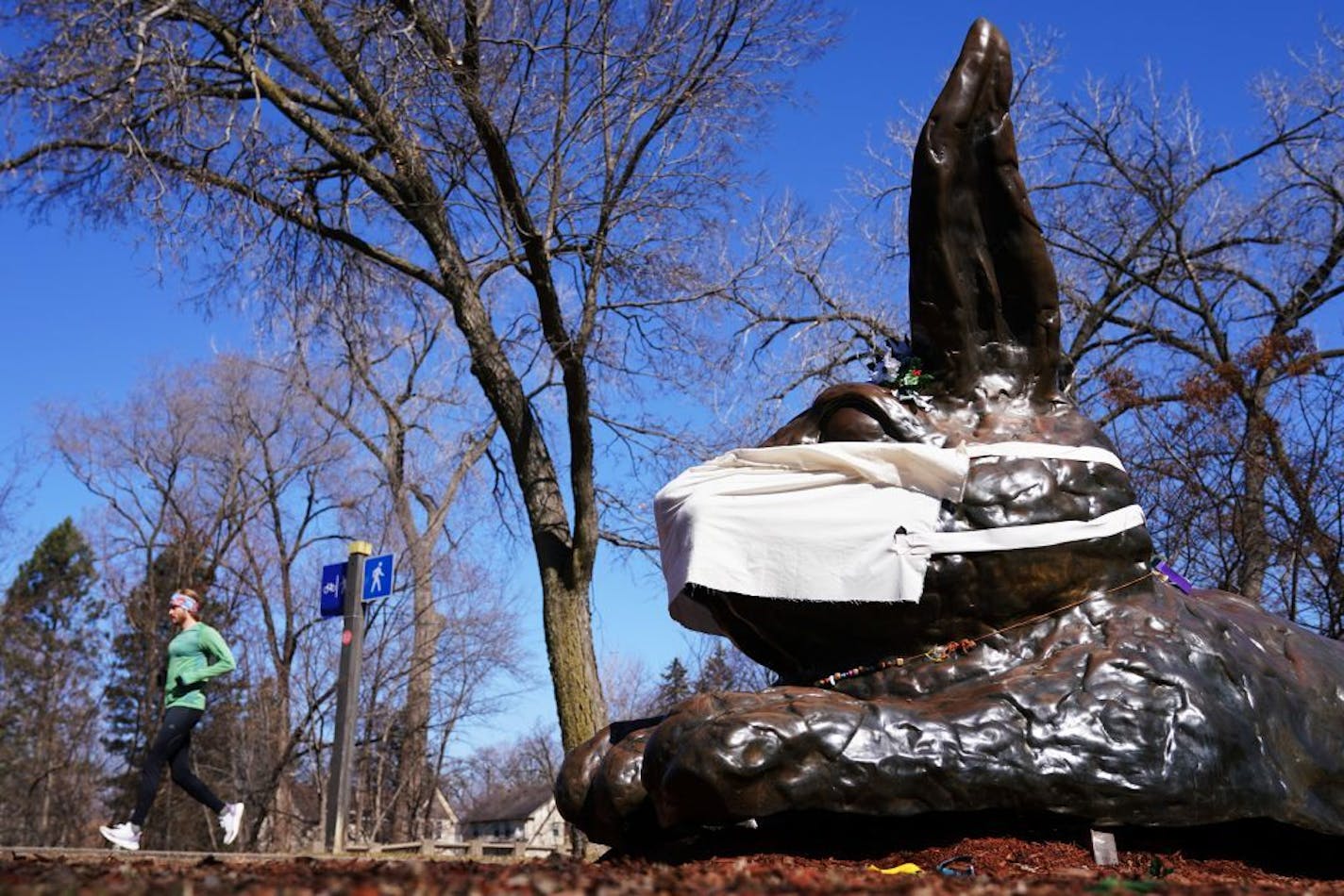 A jogger passed by the Minnehaha Bunny, which had a protective mask added amid the coronavirus pandemic, Friday in Minneapolis.