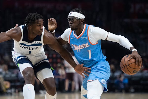 Los Angeles Clippers guard Reggie Jackson, right, drives toward the basket as Minnesota Timberwolves forward Anthony Edwards defends during the second