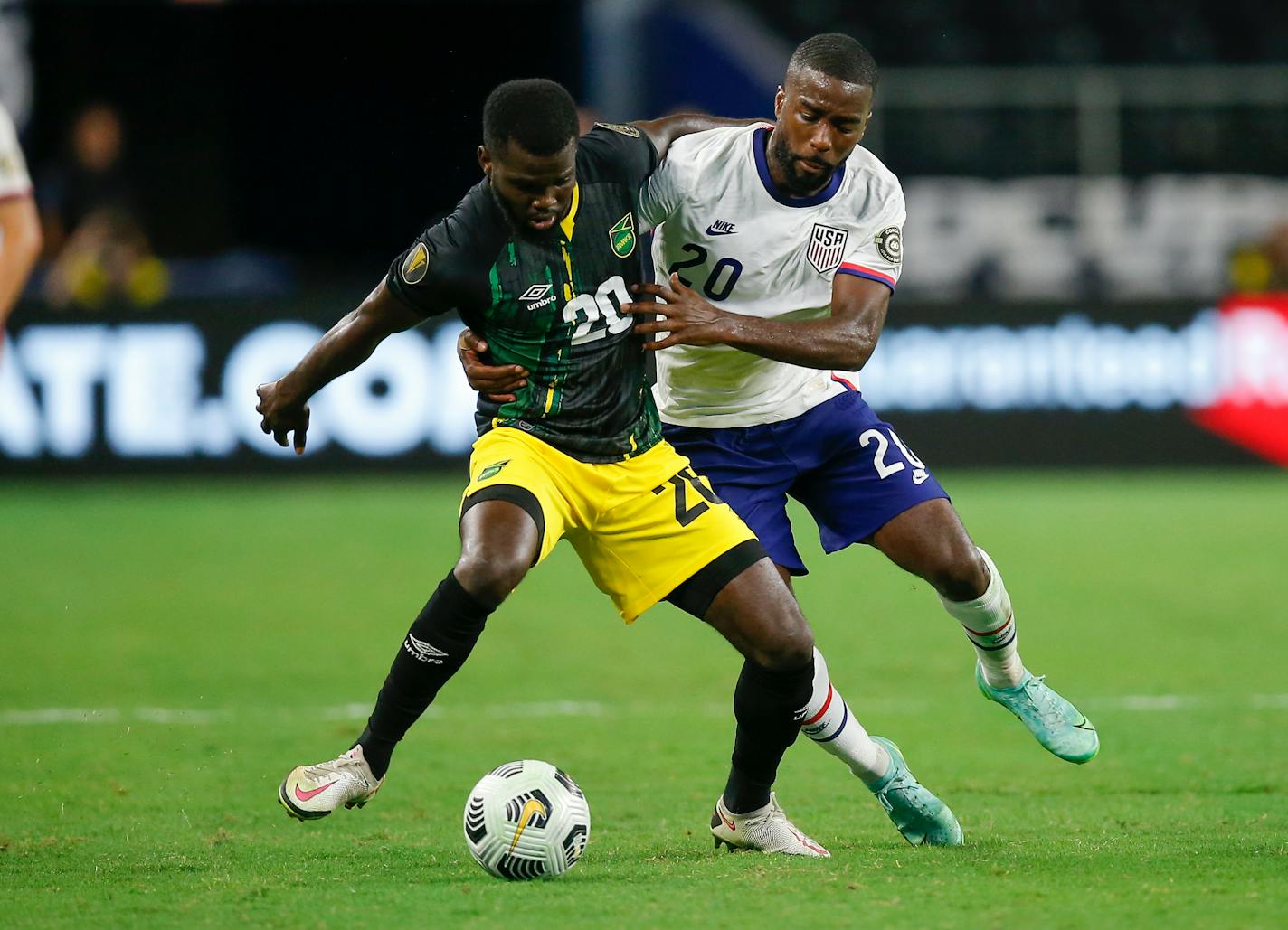 Jamaica defender Kemar Lawrence, left, and United States defender Shaq Moore, right, battle for the ball during a CONCACAF Gold Cup quarterfinals soccer match, Sunday, July 25, 2021, in Arlington, Texas. United States won 1-0. (AP Photo/Brandon Wade)