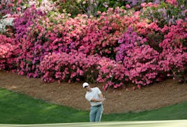 Rory McIlroy, of Northern Ireland, hits a chip on the 13th hole during practice for the Masters golf tournament at Augusta National Golf Club, Tuesday
